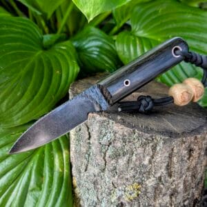 “Mowgli knife secured in an olive-colored Kydex sheath for outdoor carry.”