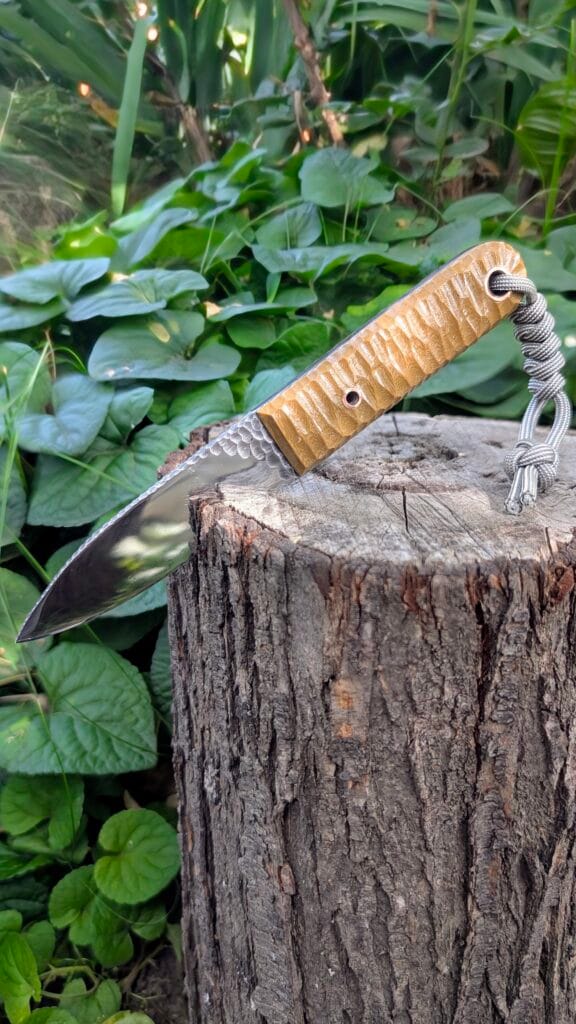 “Angled artistic photo of the Mowgli knife showing blade geometry and ergonomic handle.”