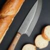 handmade kitchen knives on a cutting board with fresh ingredients